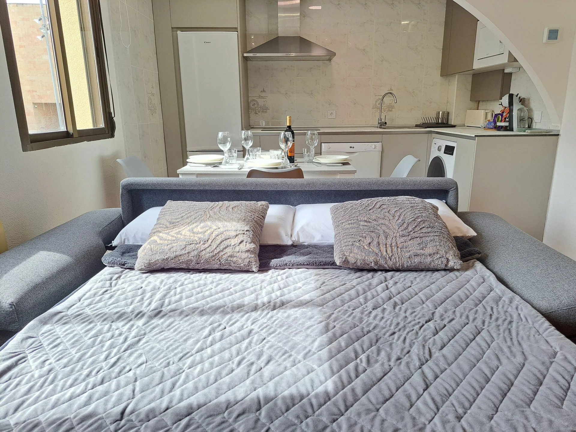 Salón con sofá cama y luz natural